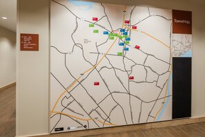 Une grande carte murale avec différents marqueurs de couleur indiquant l’emplacement des hôtels et les services qu’ils proposent.