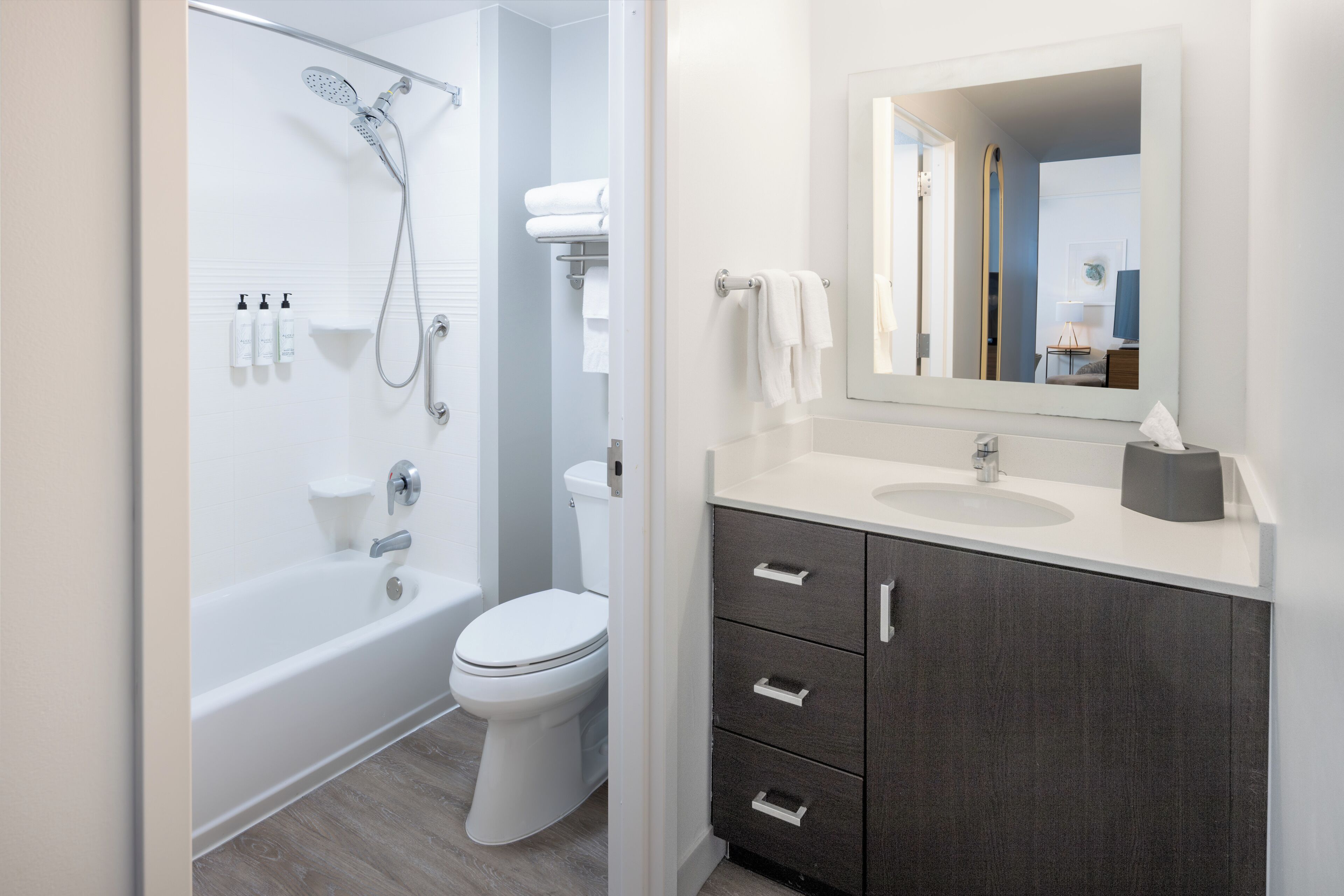 Een moderne badkamer met een bad, toilet en wastafel.