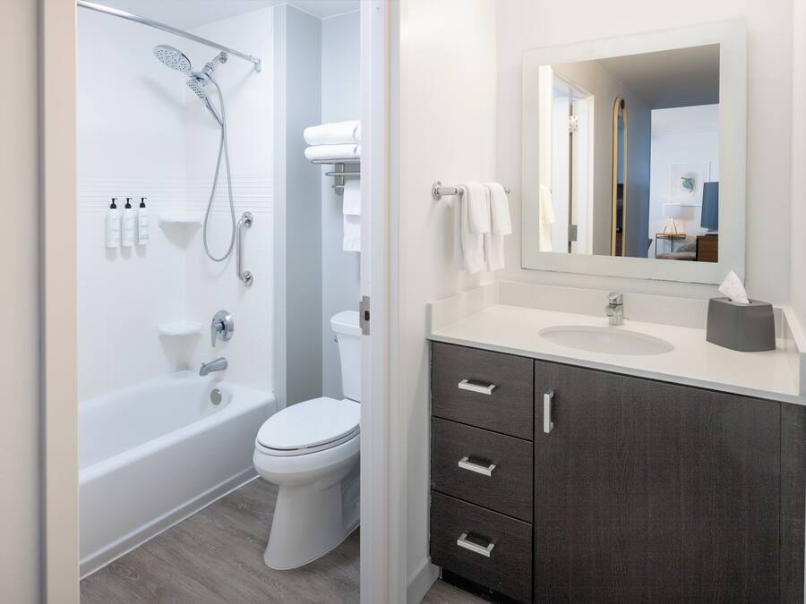 Een moderne badkamer met een bad, toilet en wastafel.