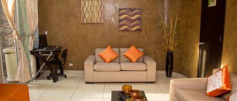 A modern living room with a sofa, coffee table, and decorative items.