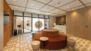 Un hall d’entrée moderne doté d’un espace salon circulaire, d’un comptoir d’accueil et d’un sol à motifs.