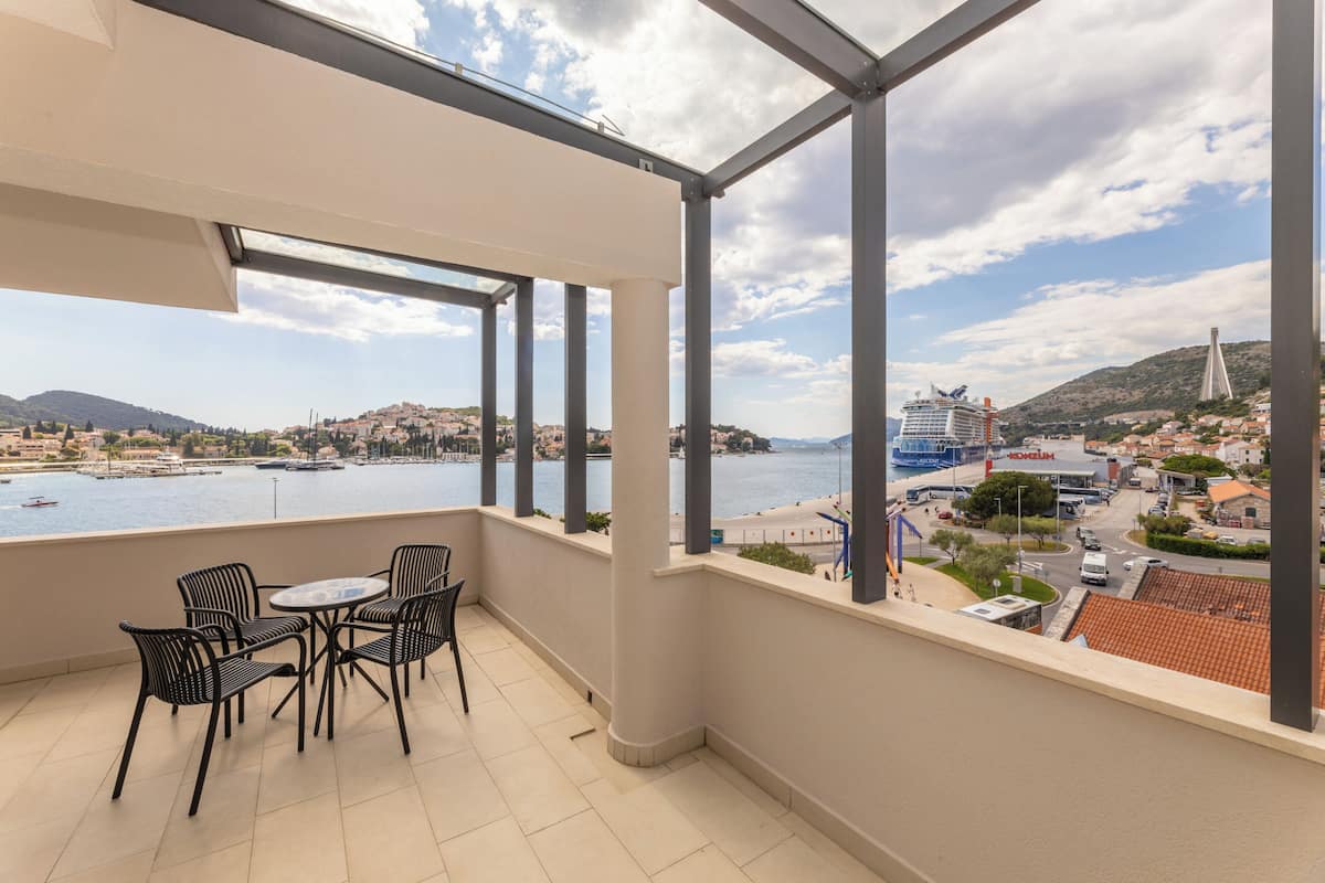 A balcony with a view of a marina and cityscape.