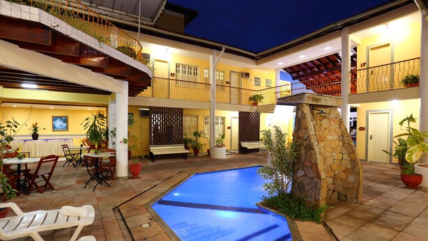 A multi-level hotel with a swimming pool, outdoor seating, and multiple balconies. - Marlim Porto Hotel (Porto Seguro)
