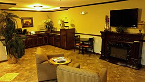 Una sala de estar con chimenea, televisor, comedor y cocina.