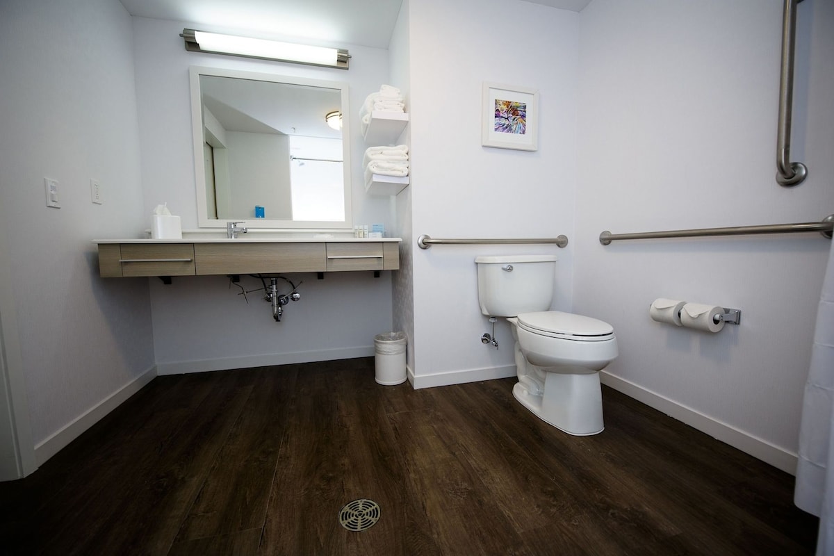 A bathroom with a toilet, sink, and mirror.