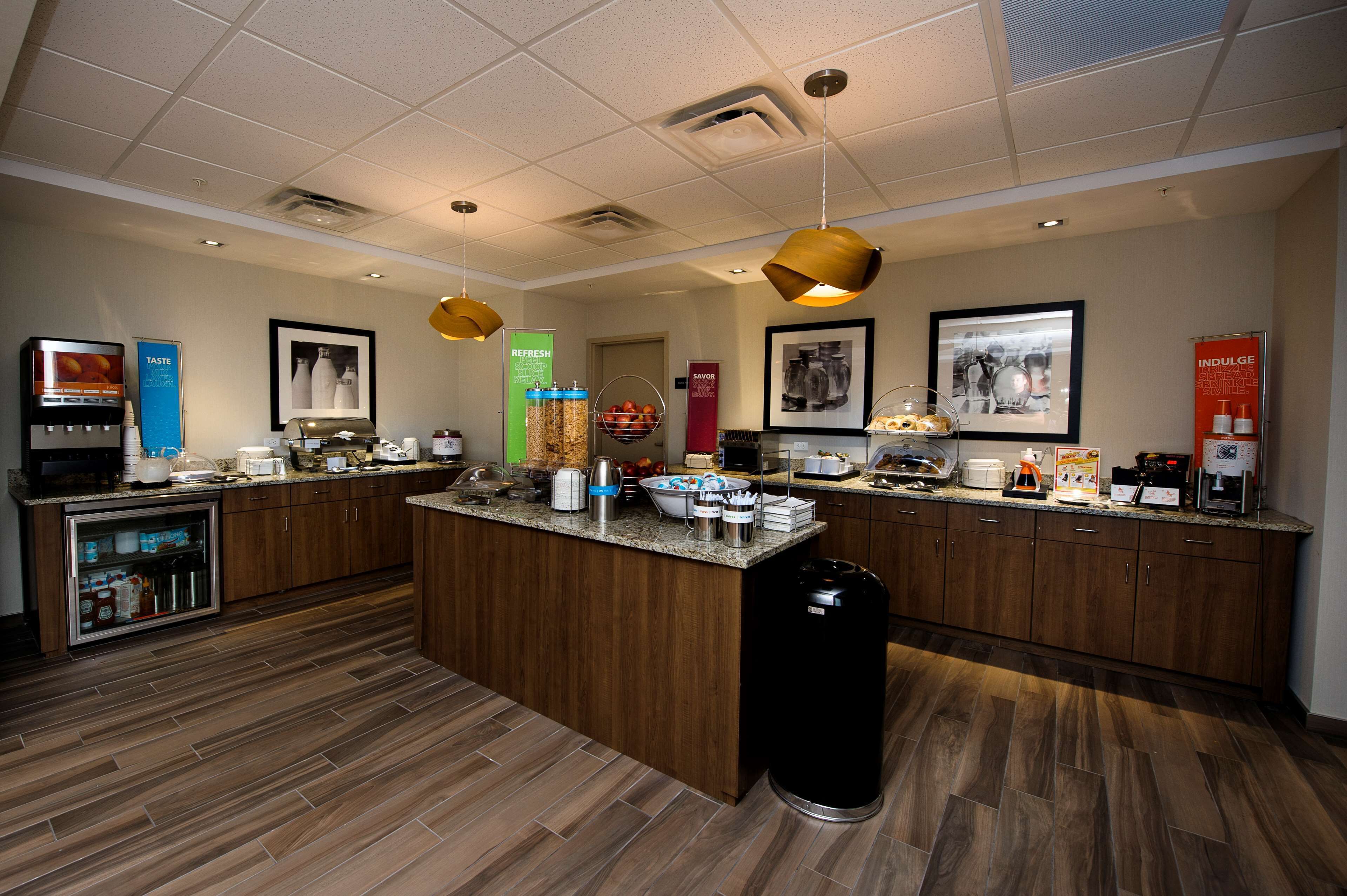 A modern kitchen with a central island, various appliances, and a trash can.