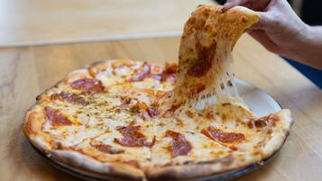 A pizza with pepperoni on a wooden table.