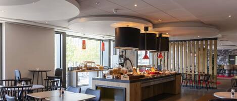 Un intérieur de restaurant moderne avec un bar central, des tables rondes et des chaises noires.