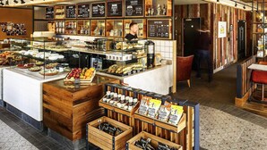 A bakery counter with various baked goods and coffee options. - ibis Cambridge Central Station (Cambridge)