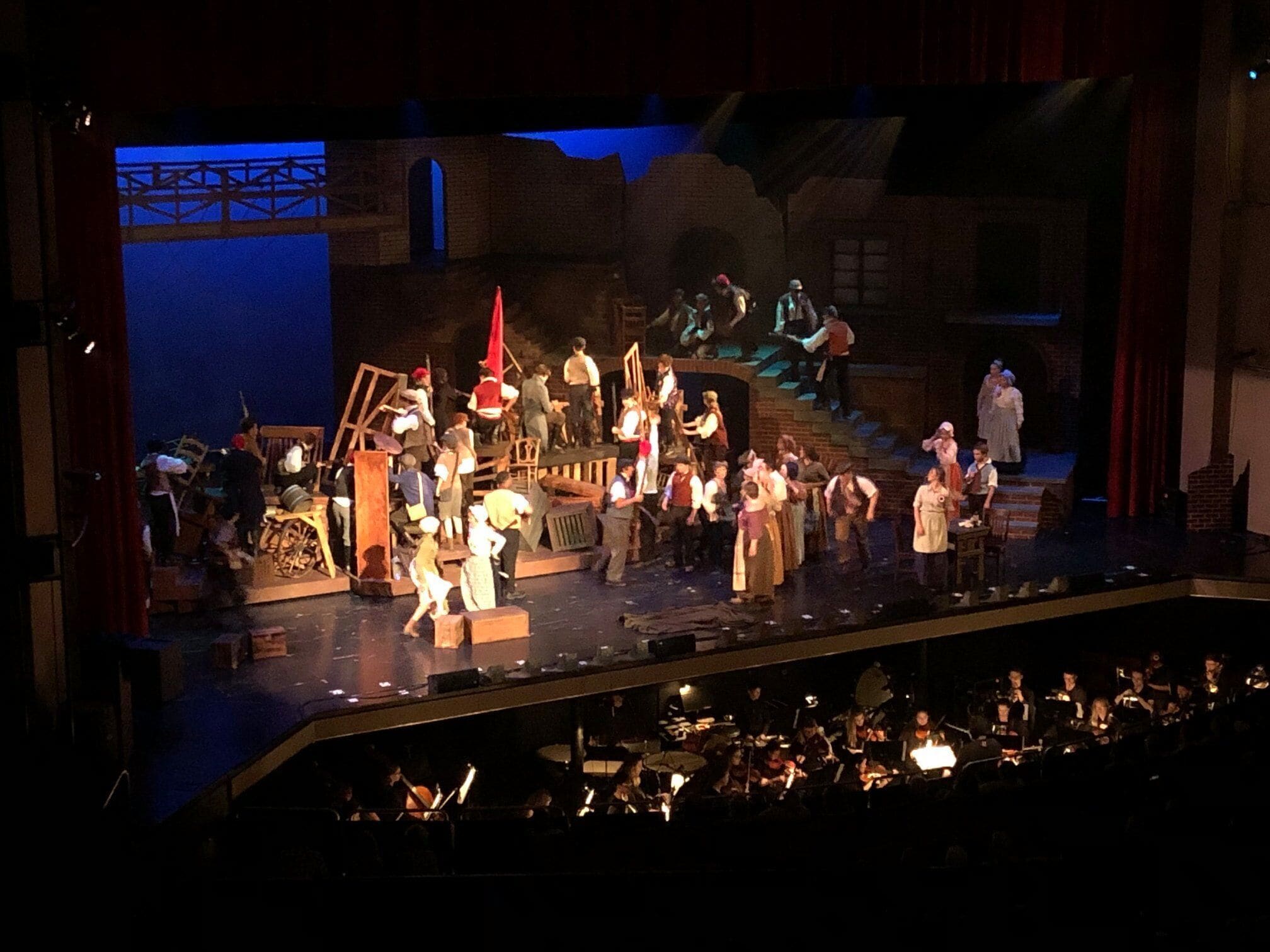 Une scène de théâtre avec des acteurs et des musiciens.