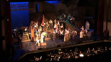 Une scène de théâtre avec des acteurs et des musiciens.
