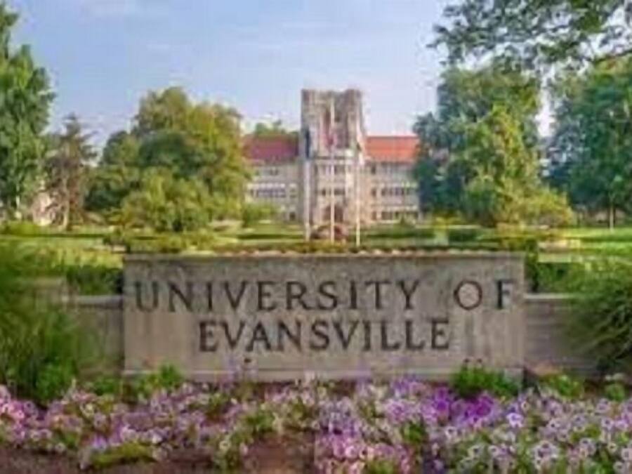 Placa indicando a Universidade de Evansville, com um edifício ao fundo.