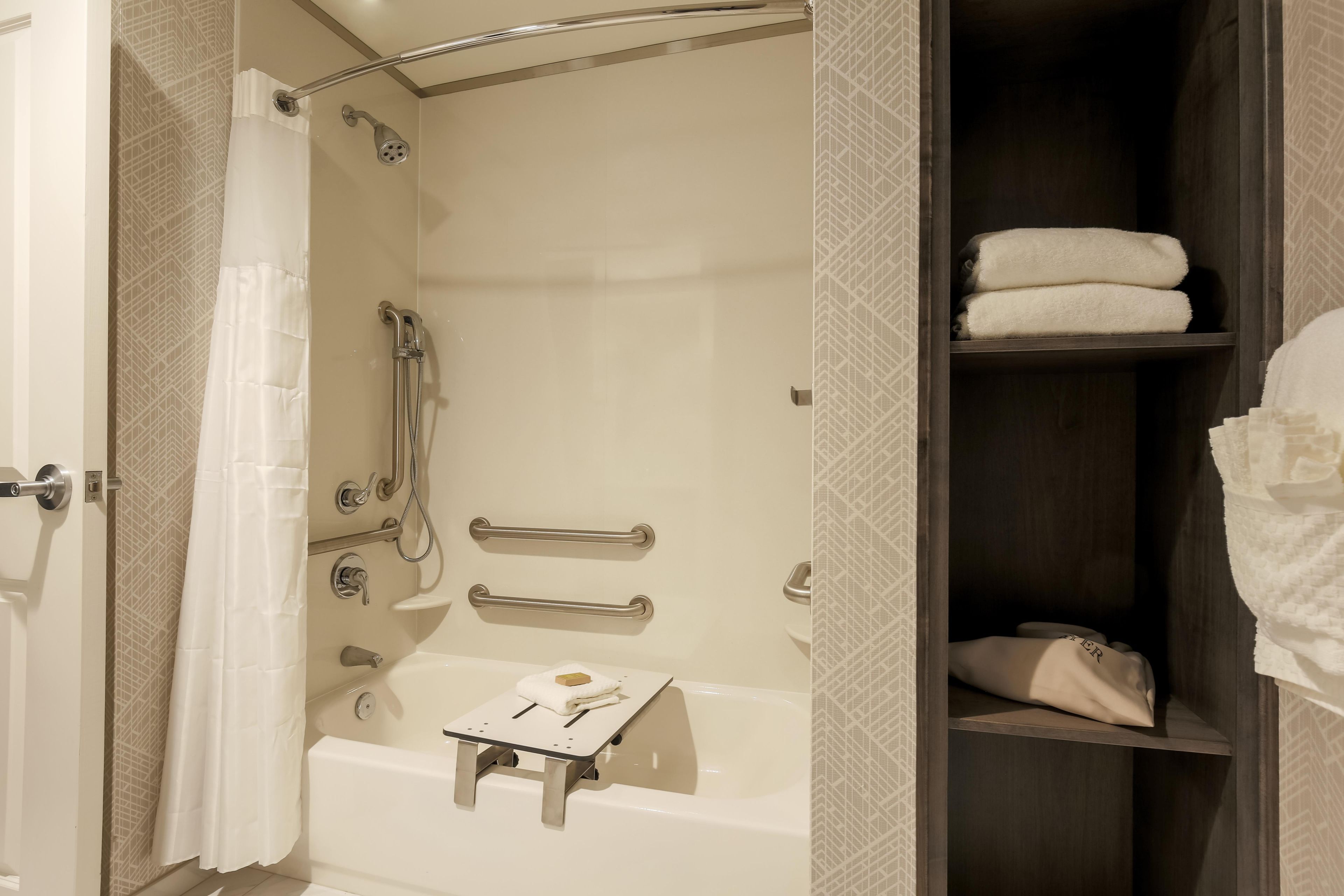 Un baño con bañera, ducha y un perchero para toallas.