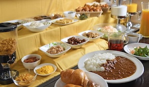Una mesa de buffet con diversos platos, incluyendo arroz, frijoles y pan.