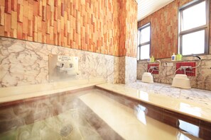 Un baño moderno con encimera de mármol, ducha de vapor y paneles de madera.