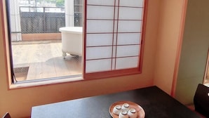 A room with a black table, a window with a view of a balcony, and a white air conditioning unit mounted on the wall. - Minshuku Inn Shirahama Ekinoyado (Shirahama)