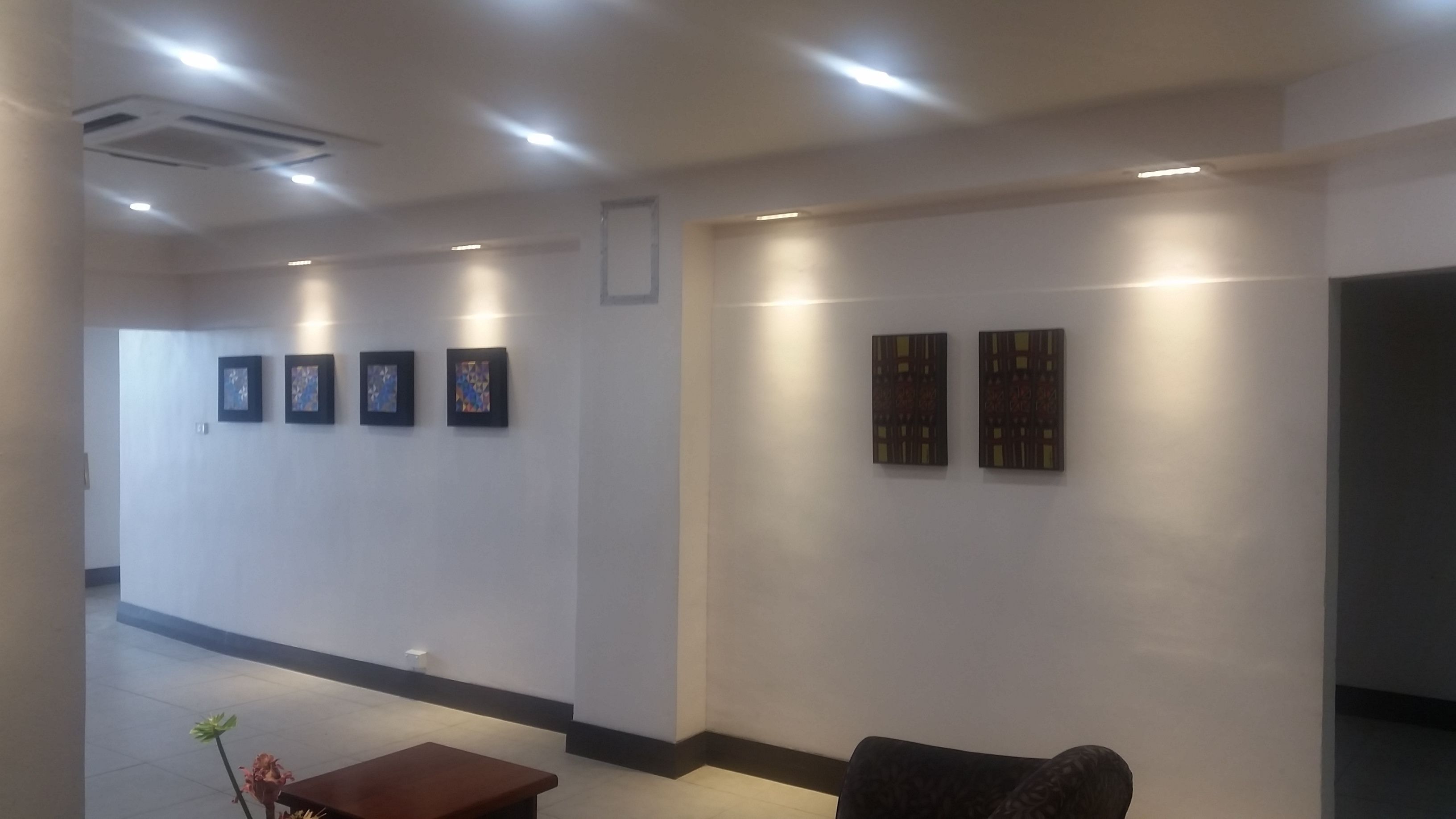 Un'area reception con una scrivania, una sala d'attesa con divano e opere d'arte alle pareti.