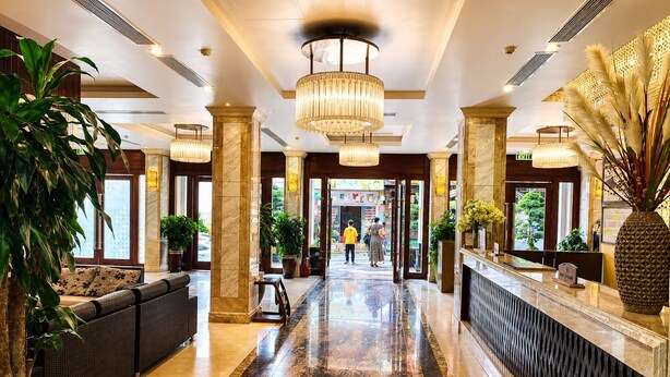A hotel lobby with a marble floor, a reception desk, and a large chandelier. - Canvas Sapa Legend Hotel (Sa Pa)