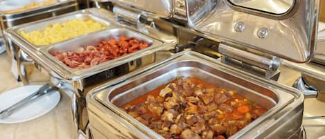 A buffet with various food items in metal containers.