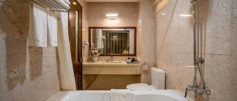 Un baño moderno con una bañera grande, ducha y tocador con espejo.