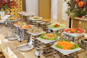 Un bufé con ensaladas y frutas variadas.
