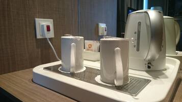 Una cafetera y dos tazas de café sobre una bandeja.