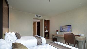 A hotel room with a bed, a desk, and a television.