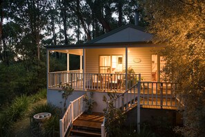 A two-story house with a covered porch and a staircase leading to the upper level. - Myers Creek Cascades Luxury Cottages (Healesville)