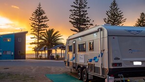 A caravan parked in a campsite with a sunset in the background. - Wallaroo Holiday Park (Wallaroo)