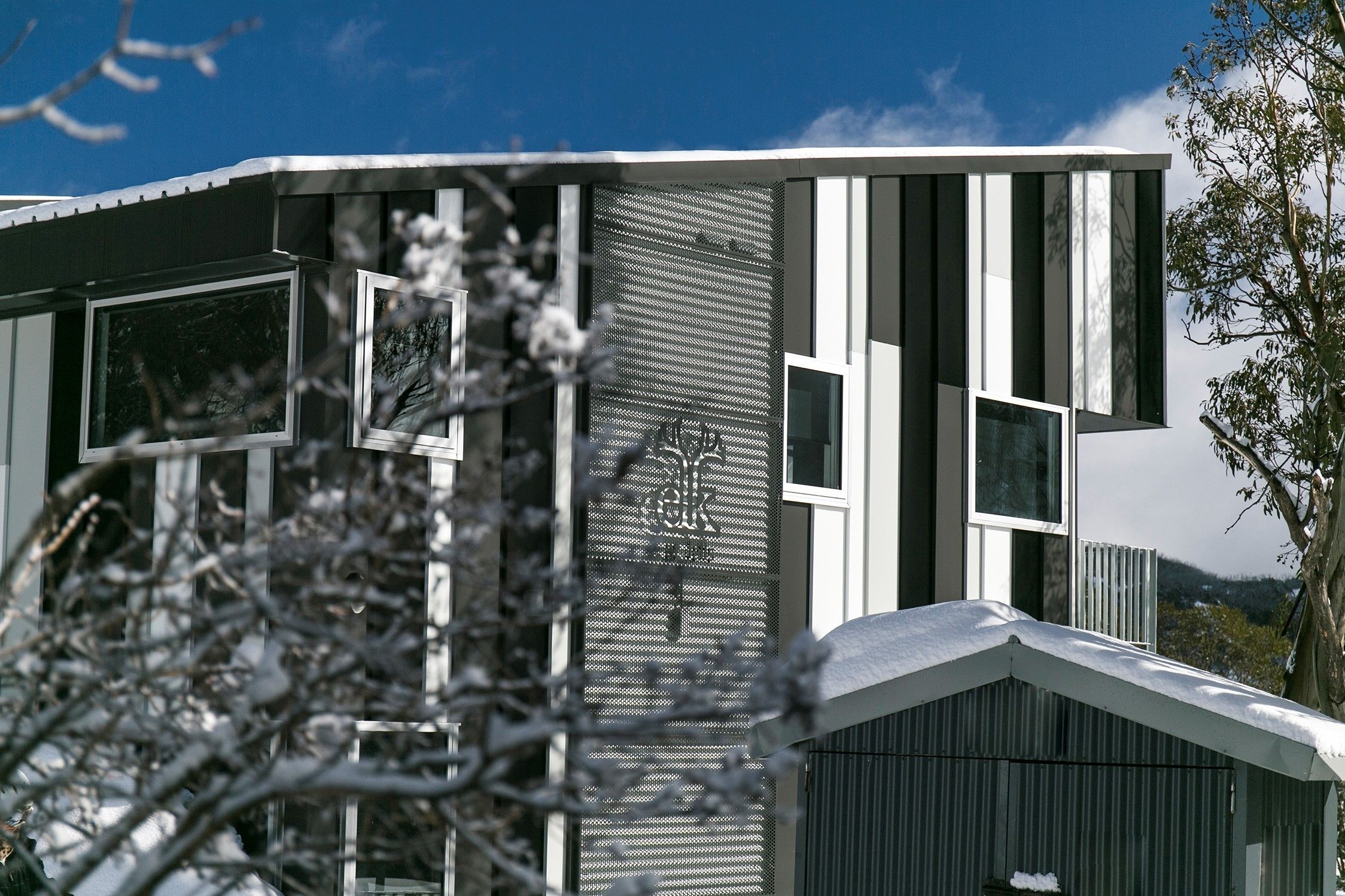 A modern building with large windows and a metal facade.