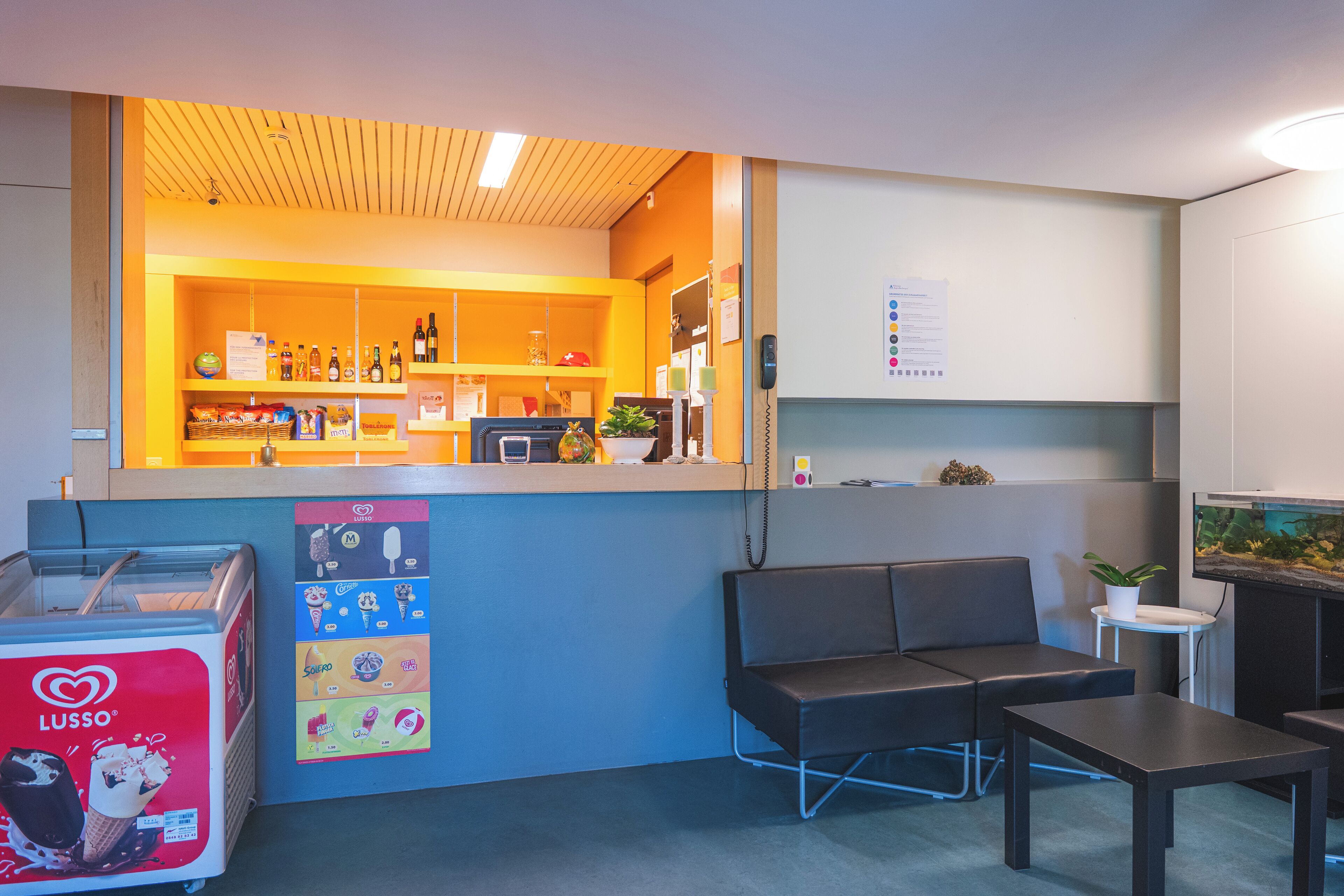 A reception area with a counter, seating, and a vending machine.