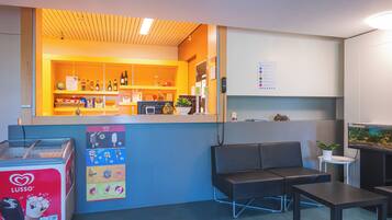 A reception area with a counter, seating, and a vending machine.