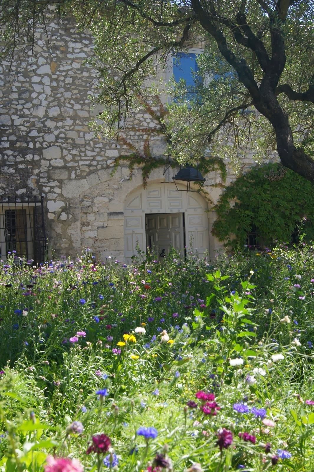A stone building with a garden in front.