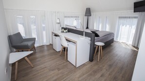 A modern hotel room with a bed, desk, chair, and a TV mounted on the wall. - Hotel Termunterzijl (Termunterzijl)