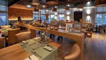 A restaurant with wooden tables, chairs, and a bar area with bottles.