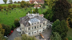 Un grand bâtiment à étages, doté d’une cour et d’un espace de stationnement.