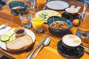A breakfast table with various food items, a coffee cup, and a glass of orange juice. - Youth Hostel Kreuzlingen (Kreuzlingen)