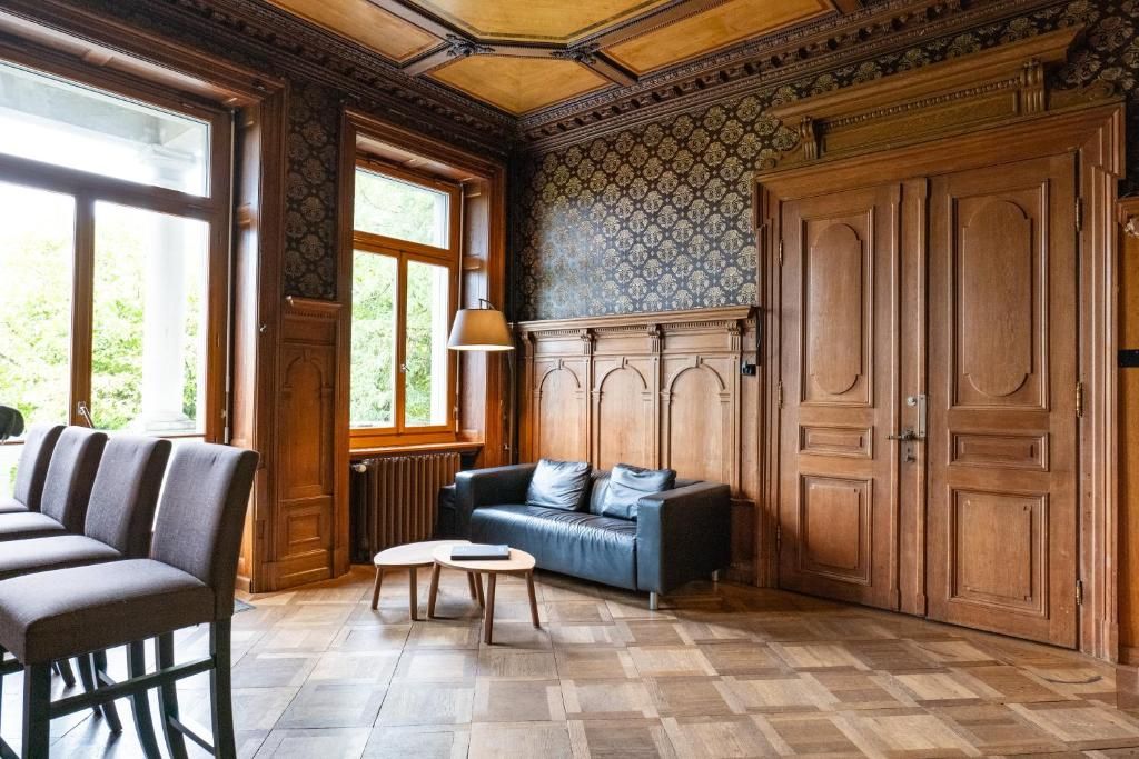 Une pièce avec un sol à carreaux, un canapé, une table et une grande armoire en bois.