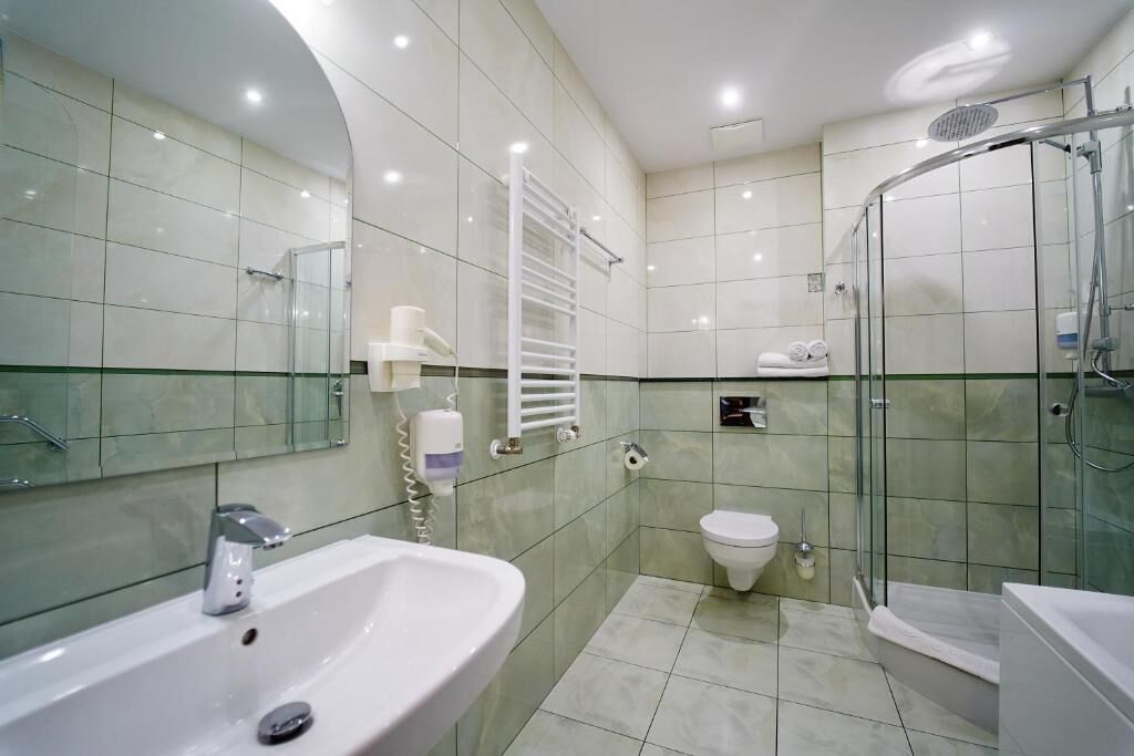 A modern bathroom with a sink, toilet, and glass-enclosed shower.
