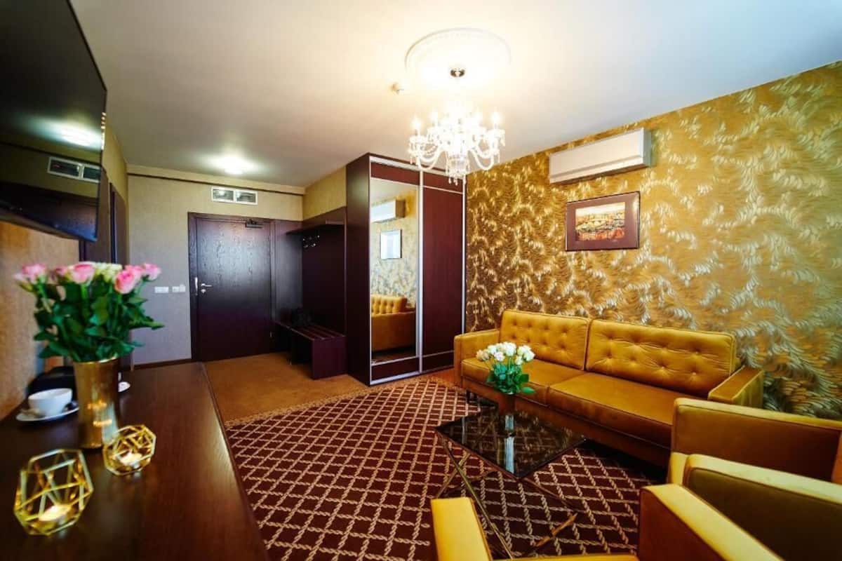 Ein modernes Wohnzimmer mit einer Couch, einem Glastisch und einem gemusterten Teppich.