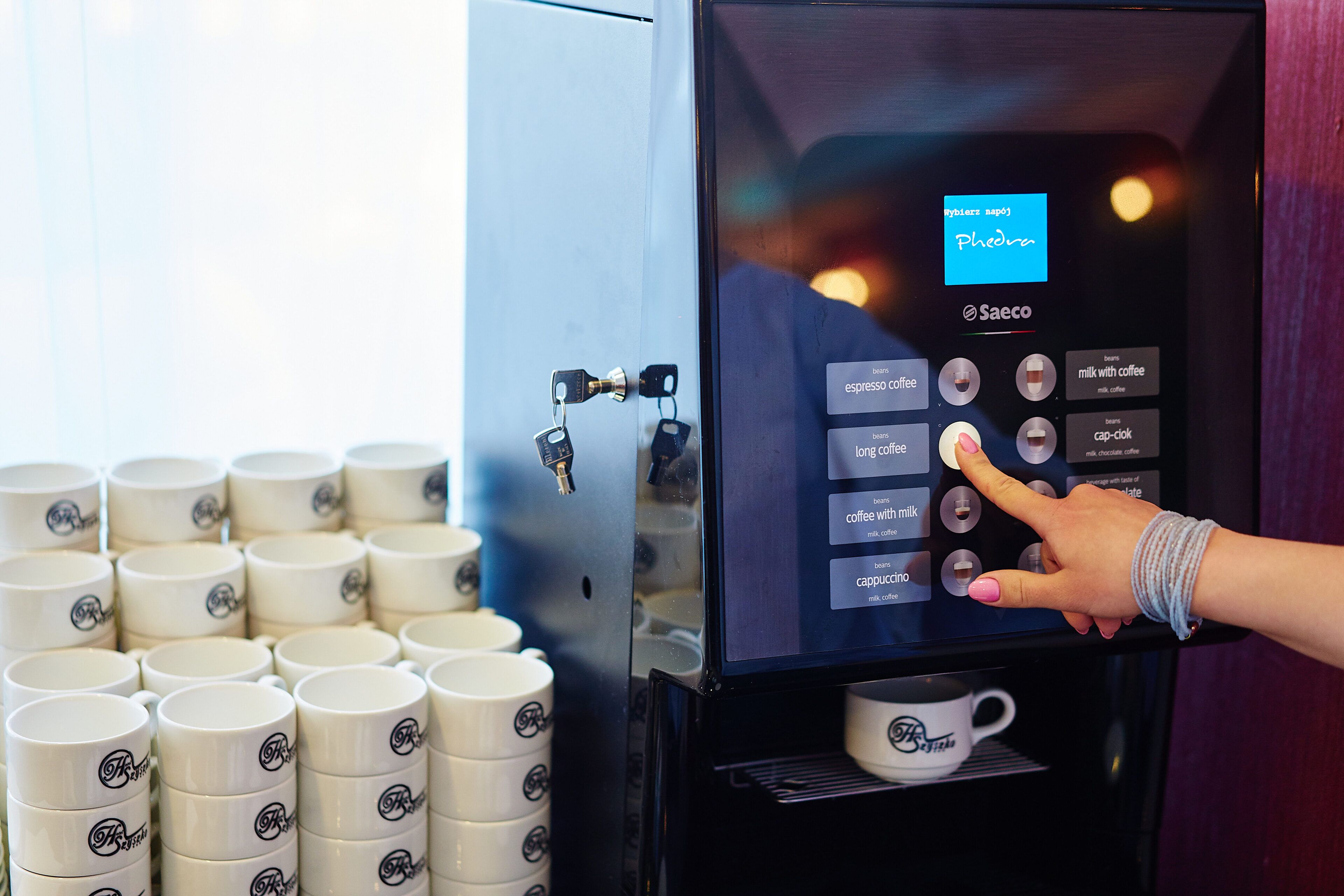Eine Kaffeemaschine mit digitaler Anzeige und verschiedenen Kaffeesorten.