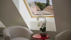 Una habitación con tragaluz, una mesa roja y dos sillas.
