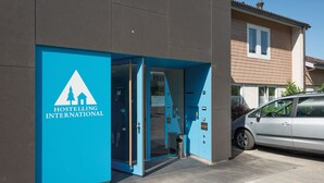 En moderne bygning med en blå indgang, hvor der står "Hostelling International".