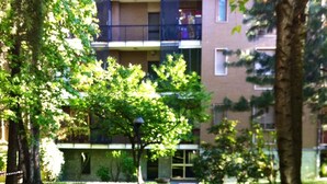 A pathway leading to a building with multiple balconies and a brick facade. - MI.style (Milan)