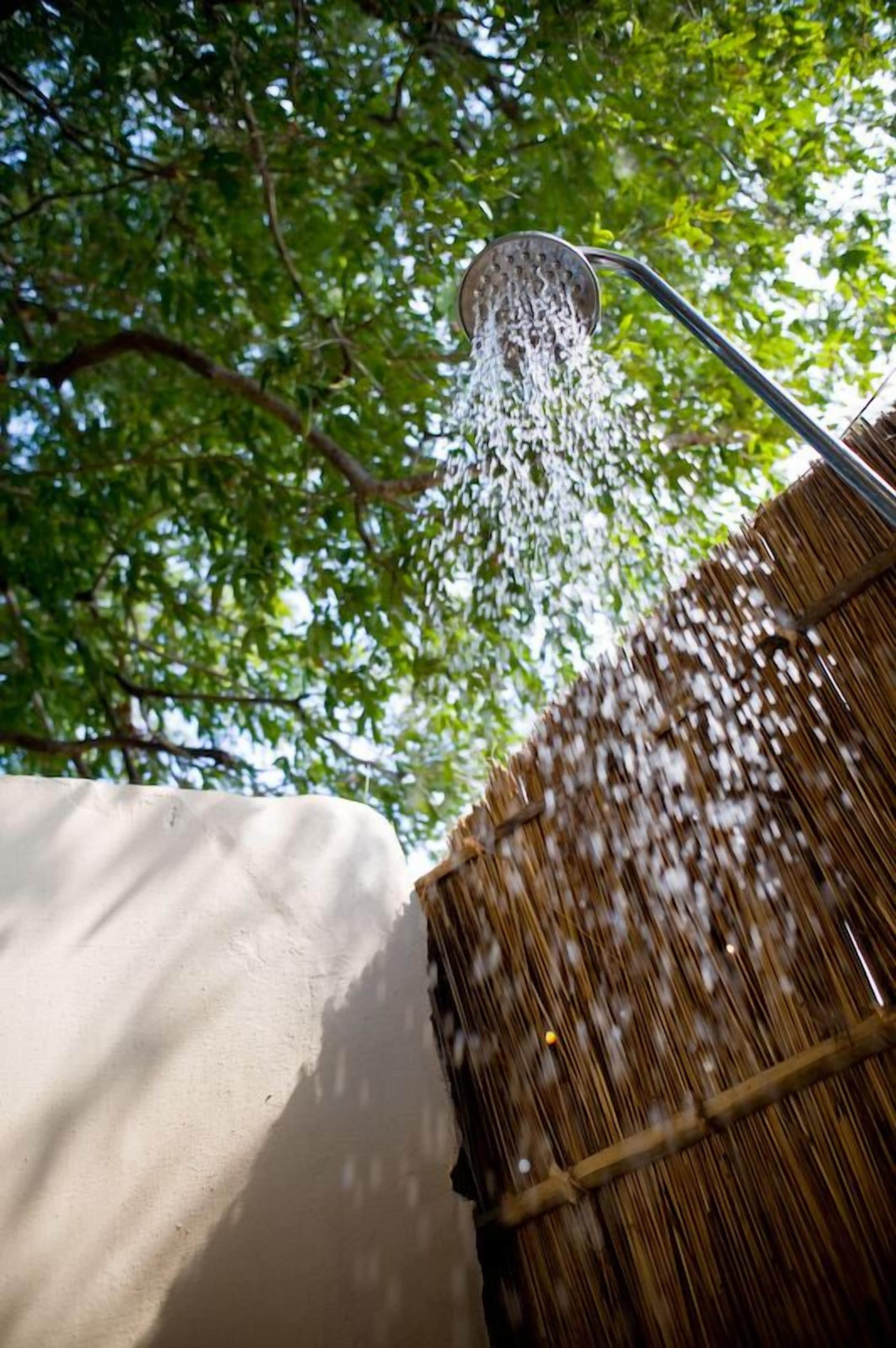 A showerhead with water flowing into a straw roof structure.