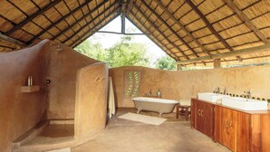 A bathroom with a bathtub, a sink, and wooden cabinets.