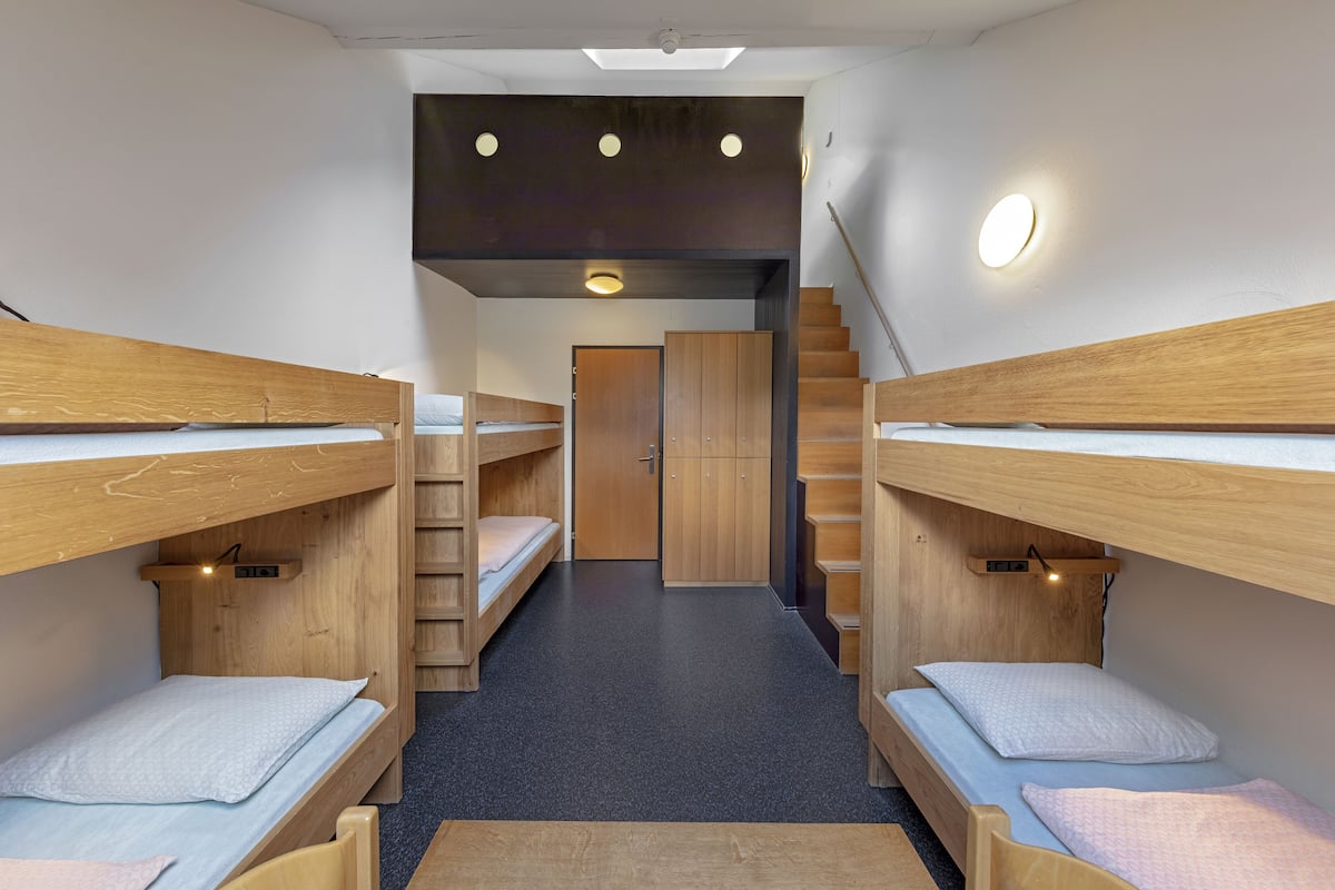 A dormitory room with bunk beds, a staircase, and a skylight.