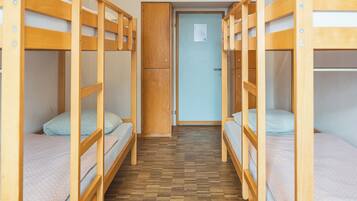Ein Zimmer mit Etagenbetten, einem Holzschrank und einer Tür mit einem Hinweis.