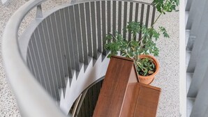 A spiral staircase with a potted plant on the landing. - Youth Hostel Richterswil (Richterswil)