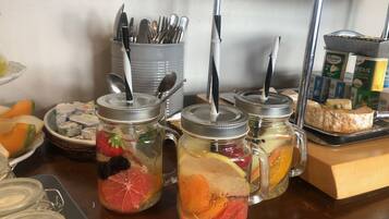 Un buffet de petit-déjeuner comprenant des boissons aromatisées aux fruits, des ustensiles et des produits laitiers.